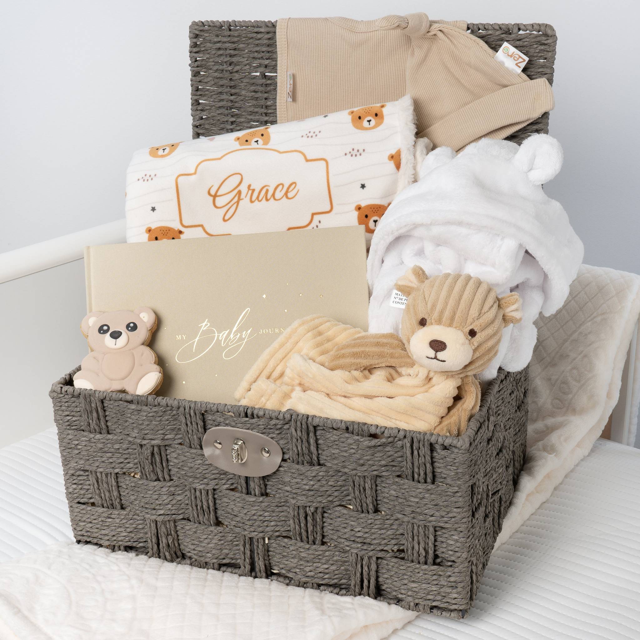 Gray wicker baby gift basket with baby items on a white surface